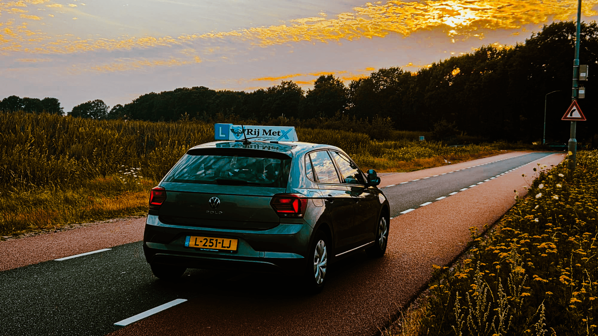 Lesauto van Rij MetX bij zonsondergang op een landweg bij Eindhoven